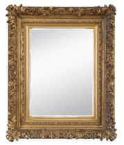 A mirror contained in a heavy gilded composite frame