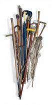 A collection of 19 walking sticks including some parasols