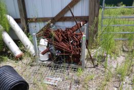 Damaged metal carrying cage with contents including rebar pieces and gaskets
