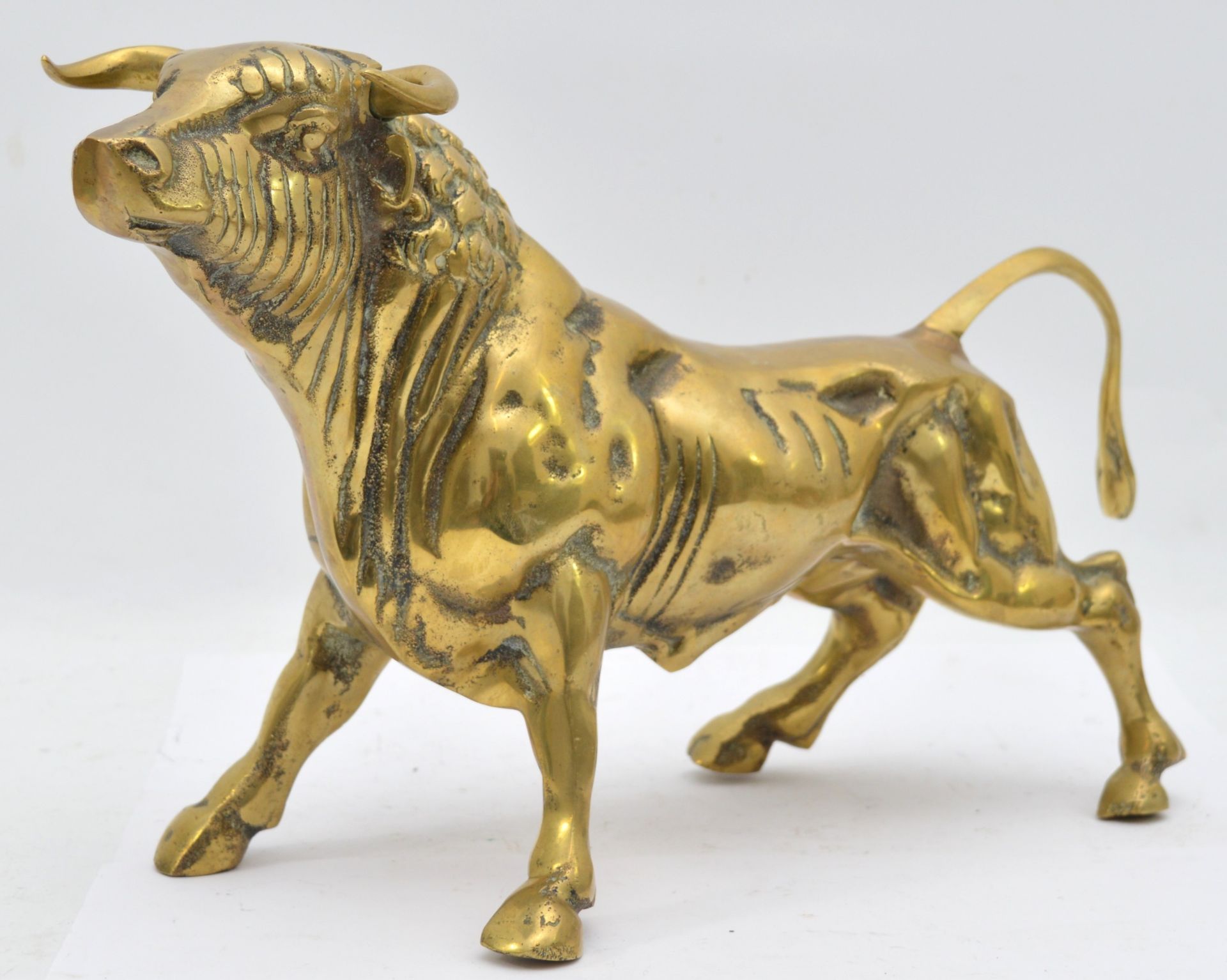 A large brass model of a bull, of substantial weight, likely used for shop window advertisements,