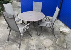 A round patio table featuring a metal frame and tempered glass top with a parasol hole and four