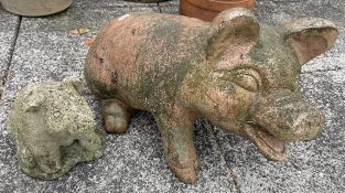 A terracotta garden ornament in the form of a pig 54cm long, together with a smaller concrete