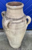 A terracotta amphora garden planter featuring four turned handles 81cm high.