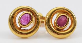 A pair of unmarked 9ct gold pink sapphire earrings with scroll backs, 0.8g