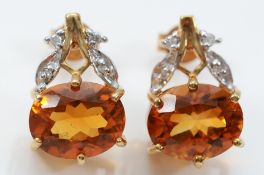 A pair of 9ct gold brilliant cut diamonds and citrine earrings with scroll backs, 15mm drop, 4g