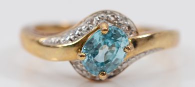 A 9ct gold brilliant cut diamond and blue topaz cross over ring, Birmingham 2007, N, 3g