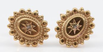 A pair of unmarked 9ct gold and brilliant cut diamond earrings with scroll backs, 1.6g