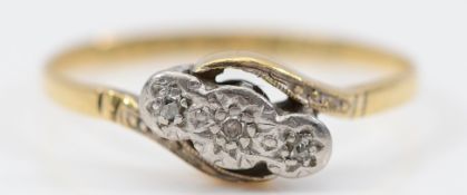 An 18ct gold and platinum diamond three stone cross over ring, N, 1.5g