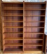 A pair of mid 20th century tall, teak effect open bookcases, having minimalist frame typical of
