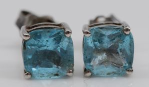 A pair of 9ct white gold blue topaz earrings with scroll backs, 1.3g