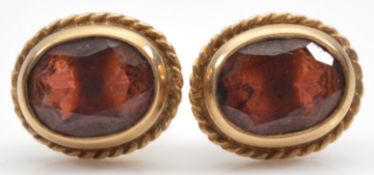 A pair of 9ct gold garnet earrings with scroll backs, 2g