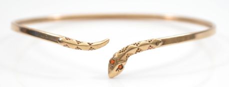 A 9ct gold snake bangle, with garnet eyes, 67mm, 4.7g