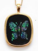 A 9ct gold black onyx pendant with an opal butterfly inlay, on a chain, 1.8g