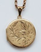 A 9ct gold circular engraved locket pendant, 28mm, 9.2g with a chain that does not test as gold.