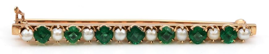 An unmarked gold seed pearl and synthetic emerald brooch, electronically tests as 9ct gold, 52mm,