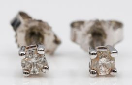 A pair of unmarked 9ct white gold brilliant cut diamond earrings with scroll backs, approximately