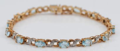 A 9ct gold blue topaz and single cut diamond bracelet, 18cm, 8.5g