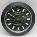 A 'Rolex' style advertising metal wall clock, green and black patterned dial with black bezel,