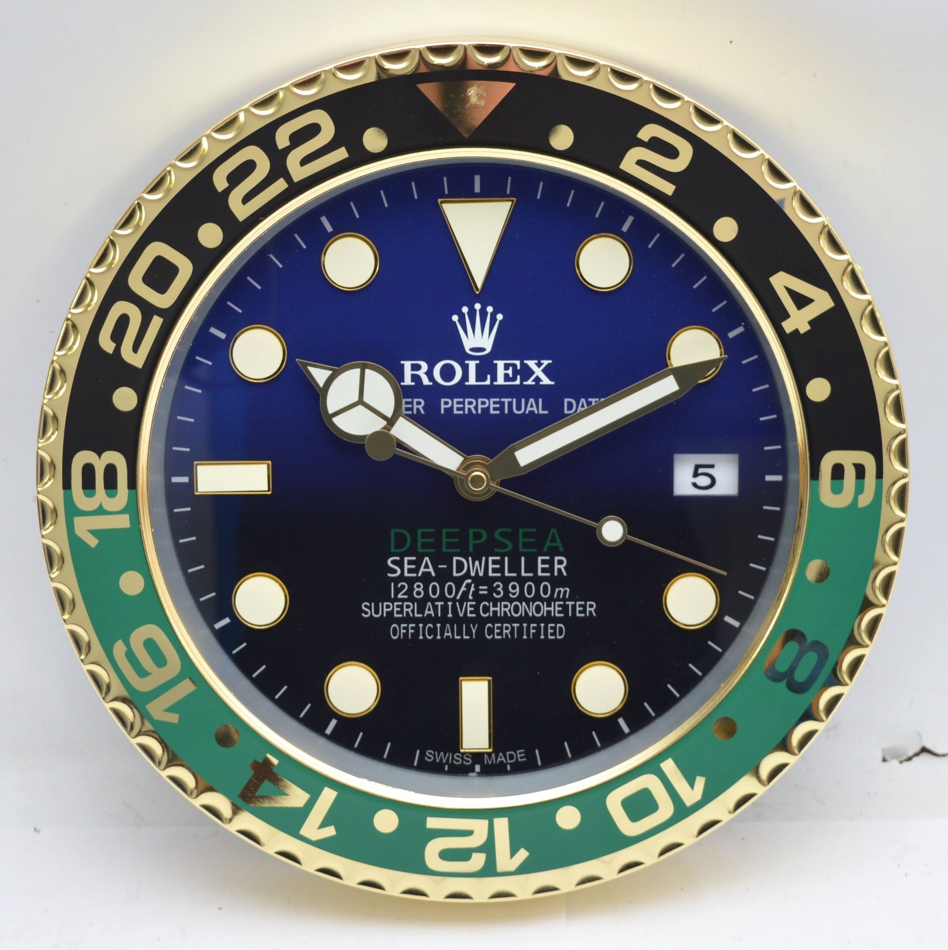 A 'Rolex' style advertising metal wall clock, blue and black gradient dial with black and green