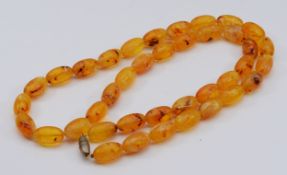 An amber beaded necklace, 25mm beads, 106cm