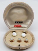 A pair of mother of pearl cuff links and shirt buttons, in a case