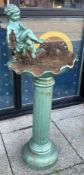 A cast iron bird bath, featuring seated cherub, in need of repair to reattach top, height 94cm.