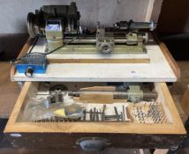 An Elliott Unimat SL mini watchmakers lathe, with a drawer of accessories and cutting tools.
