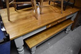 A modern farmhouse style kitchen table having golden oak top and painted frame with two similar