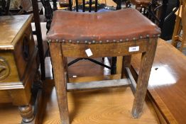 A vintage stool having studded leather seat