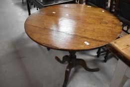 A 19th Century oak snap top table having circular top and turned column on triple splay legs,