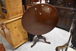A 19th Century snap top dining table having circular top having turned column and triple splay legs,