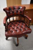 A modern red leather button back swivel chair