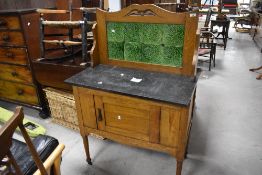 An Arts & Crafts style golden oak wash stand having marble top and tiled back, width approx. 85cm