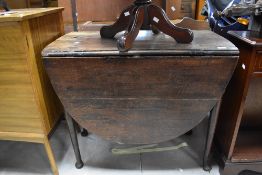 A 19th Century oak dining table having drop leaf and cabriole legs, width approx. 89cm