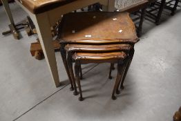 A vintage nest of three walnut tables