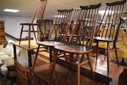 A set of five (three plus two) dark stained Ercol kitchen chairs having high spindle back chairs