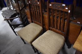 A set of four early 20th Century mahogany rail back dining chairs having Art Nouveau style carved