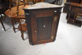 A 19th Century oak corner cupboard showing some signs of historical worm