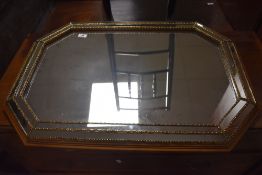 A vintage cushioned mirror, approx width 83cm