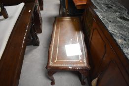 A vintage coffee table and nest in the period style with leather insets