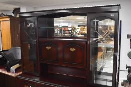 A modern mahogany lounge unit, having mirrored back and drop down cocktail section, width approx.