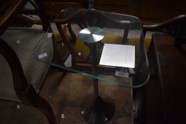 A modern chrome and glass occasional table