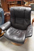 A Stressless chair having brown upholstery and alloy frame