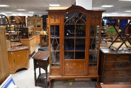 An Edwardian mahogany display cabinet , having inlaid decoration and cloth interior, on cabriole