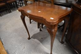 An early 20th Century walnut fold over card table, width approx. 76cm