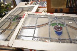 Two early 20th Century stained glass window panels still within the frames glass measuring 70cm x