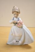 A Nao by Lladro porcelain figurine 'Girl with Posey of Flowers' measuring 19cm tall, complete with