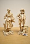 A pair of porcelain figures, one depicting a male water bearer, the other a female carrying a basket