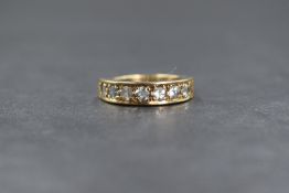 A 9ct gold band ring having seven pave set paste stones on a 9ct gold loop, size O & approx 2.5g