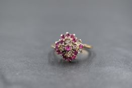 A 9ct ruby and diamond set cluster ring, the central round cut ruby in an illusion diamond chip